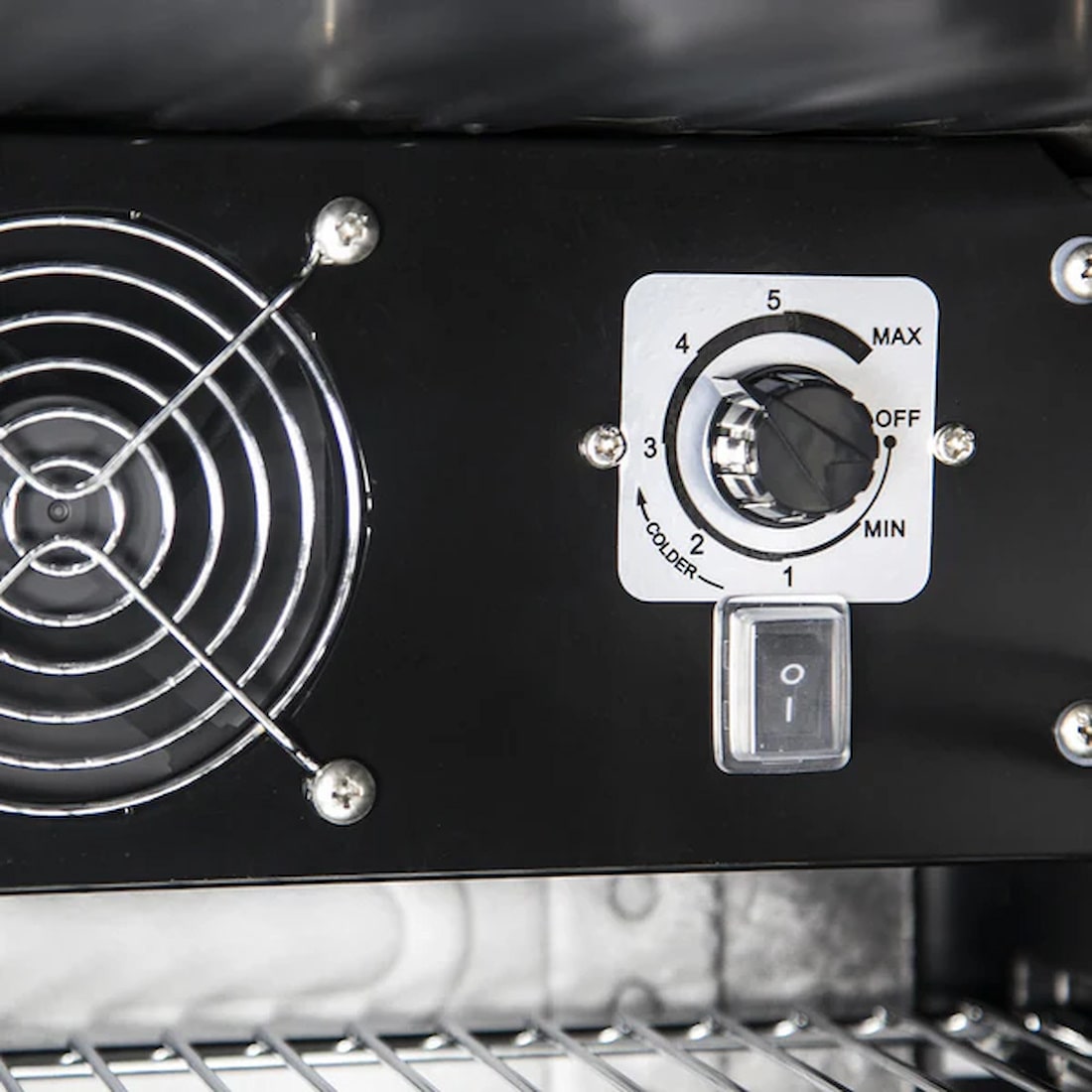 the inside of a bar fridge showing the internal fan and temperature control