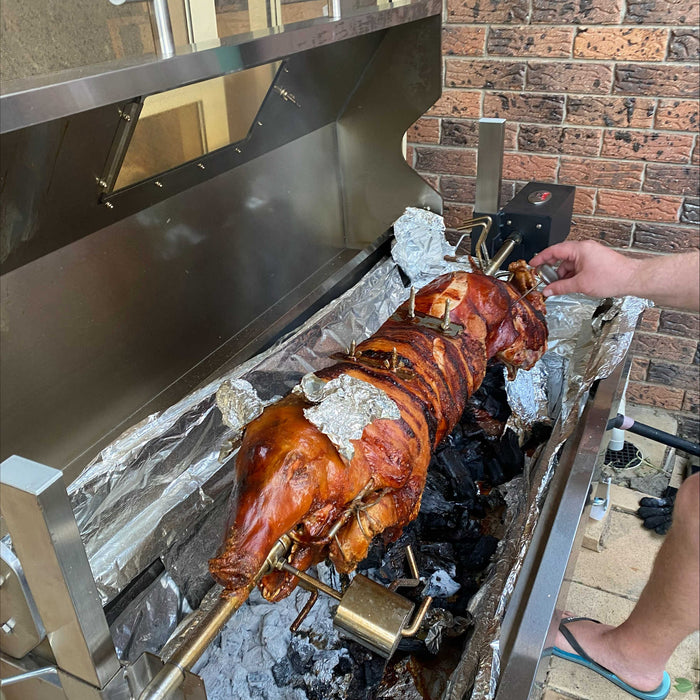 1200mm spartan spit roaster with a whole pig cooking on it