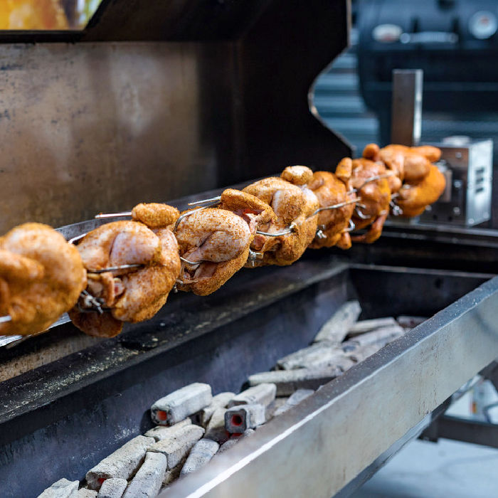BBQ Spit and rotisserie collection by outdoor living australia. Picture shows a 1500 mm spartan hooded rotisserie with 8 whole chickens cooking