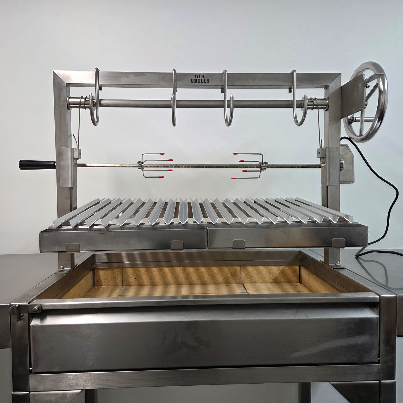 parrilla argentine asado grills showing an OLA Grill model with meat hooks and rotisserie kit