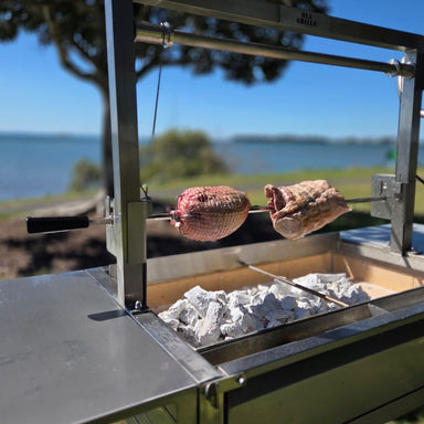 Rotisserie Kit For the OLA Grills Parrilla BBQ's | Multiple Models showing the rotisserie kit with meat cooking