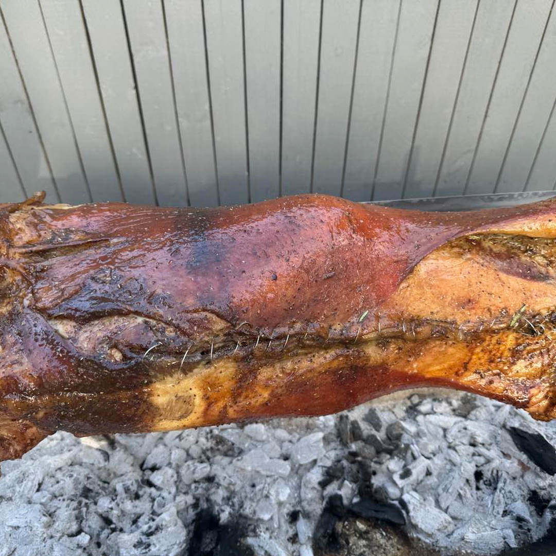 a whole lamb cooking ona  spit from a customers house