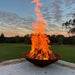 Mega cauldron 1500 mm with raging fire inside close up in a large backyard
