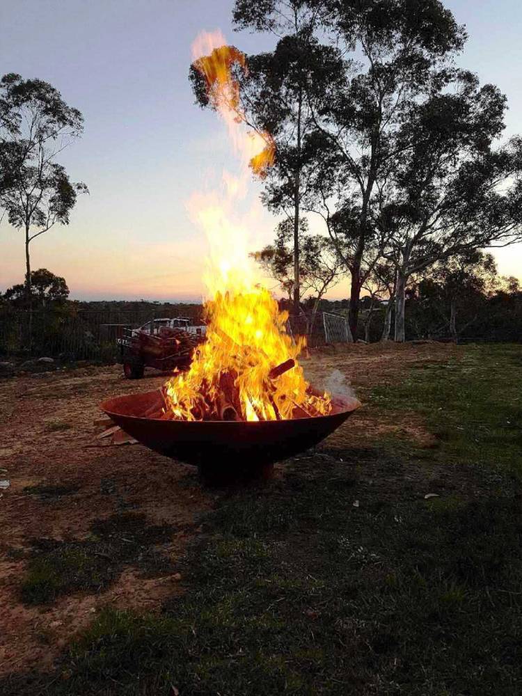 Outdoor Fire Pit: the cauldron hearth with BBQ Grill with a roaring fire in an outdoor space